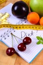 Fruits, tablets supplements and centimeter with notebook, slimming and healthy food