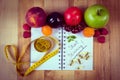 Fruits, tablets supplements and centimeter with notebook, slimming and healthy food