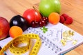 Fruits, tablets supplements and centimeter with notebook, slimming and healthy food