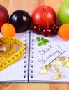 Fruits, tablets supplements and centimeter with notebook, slimming and healthy food