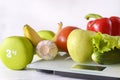 Fruits and vegetables, dumbbell, are placed on white electronic scales Royalty Free Stock Photo