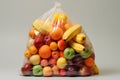 Fruits and vegetables in a plastic bags on white background