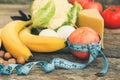 Fruits and vegetables, tape measure on old wooden background. Concept of proper nutrition. Royalty Free Stock Photo