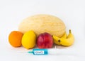 Fruits on a white background bananas, orange, melon, lemon and nectarine, next is a syringe with gmo and nitrates Royalty Free Stock Photo