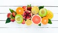 Fruits on a white wooden background. Mango, melon, pomegranate, strawberry, banana. Top view. Royalty Free Stock Photo