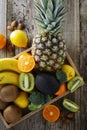 Fruits on wooden background - pineaple, tangerine, orange, citrus fruits, kiwi, broccoli. Healthy food, lose weigh. Copy space.
