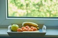 Fruits in a wooden box. on the windowsill. peaches. banana. green apple. Top view. Tropical fruit diet. Vegan food Royalty Free Stock Photo