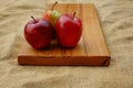 Fruits on a wooden cutting board - two apples and a pear