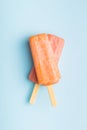 Fruity ice lolly. Sweet popsicle on blue table