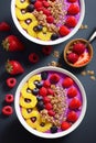 Fruity smoothie bowls topped with granola and fresh berries