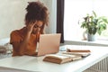 Frustrated African descent young woman in front of laptop at home, receiving e-mail with bad news Royalty Free Stock Photo