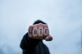 Frustrated , aggressive teenage boy showing hes fist with the word hate