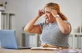 Frustrated, angry, annoyed business woman reading emails on a laptop in a modern office. Young professional worker