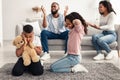 Upset black children covering ears, parents arguing in the background Royalty Free Stock Photo