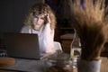 Frustrated woman working on laptop till late at work