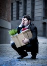 Frustrated business man on street fired carrying cardboard box Royalty Free Stock Photo
