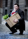 Frustrated business man on street fired carrying cardboard box Royalty Free Stock Photo