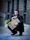 Frustrated business man on street fired carrying cardboard box Royalty Free Stock Photo