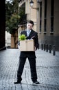 Frustrated business man on street fired carrying cardboard box Royalty Free Stock Photo