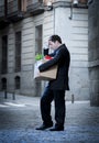 Frustrated business man on street fired carrying cardboard box Royalty Free Stock Photo