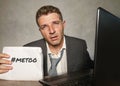 Frustrated businessman desperate at office computer desk holding notepad with the hashtag me too metoo as exploited employee Royalty Free Stock Photo