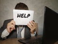 Frustrated businessman desperate at office computer desk holding notepad with the hashtag me too metoo as exploited employee Royalty Free Stock Photo