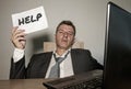 Frustrated businessman desperate at office computer desk holding notepad with the hashtag me too metoo as exploited employee