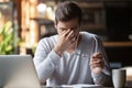 Frustrated businessman holding glasses feel eye strain, computer syndrome