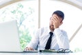 Frustrated businessman sitting behind his laptop while working at office desk Royalty Free Stock Photo