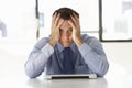 Frustrated Businessman Sitting At Desk In Office Using Laptop Royalty Free Stock Photo