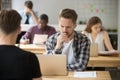 Frustrated businessman working on laptop in co-working, thinking