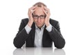 Frustrated businessman wearing glasses sitting at desk with head