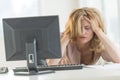 Frustrated Businesswoman With Hands In Hair Sitting At Desk Royalty Free Stock Photo