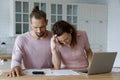 Frustrated concerned millennial married couple calculating overspend budget