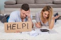 Frustrated Couple Holding Help Sign