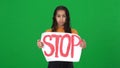 Frustrated depressed African American teenage girl showing Stop message banner looking at camera with sad facial