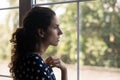 Frustrated depressed millennial woman looking out window