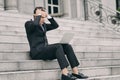 Frustrated and depressed young business man sitting on stairs while working with his laptop Royalty Free Stock Photo