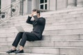 Frustrated and depressed young business man sitting on stairs while working with his laptop Royalty Free Stock Photo