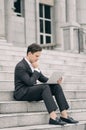 Frustrated and depressed young business man sitting on stairs while working with his laptop Royalty Free Stock Photo