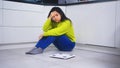 Frustrated dieting young asian woman sitting on the flor with weight scale in front. Weight loss and mental health Royalty Free Stock Photo