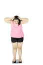 Frustrated fat woman stands on scale Royalty Free Stock Photo