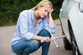 Frustrated Female Driver With Tire Iron Trying To Change Wheel Royalty Free Stock Photo