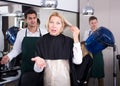 Frustrated female pensioner having fight with hairdresser Royalty Free Stock Photo