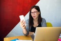 Frustrated female in spectacles professional website content creator reading terrible news in e-mail on cell telephone