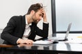 Frustrated male office employee in suit received fired or bankruptcy notification