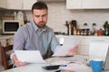 Frustrated man calculating bills and taxes expenses Royalty Free Stock Photo