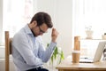 Frustrated man feeling loser sitting near laptop shocked by bankruptcy