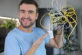 Frustrated man holding many tangled wires Royalty Free Stock Photo