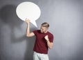 Frustrated man holding white blank speech bubble.